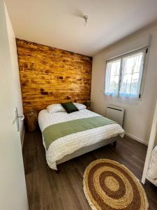 een slaapkamer met een bed en een houten muur bij El Rio Champenois in Châlons-en-Champagne