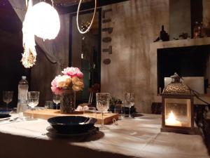 una mesa con chimenea y una mesa con flores. en Stone story AlbA, en Okrug Donji