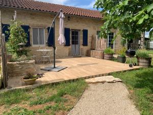 dom z drewnianym tarasem i parasolem w obiekcie gîte La Longère bleue w mieście Caylus