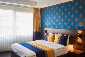 a bedroom with a bed and a blue wall at Seven Dreams Hotel in Istanbul