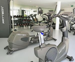 einen Fitnessraum mit mehreren Laufbändern und Maschinen darin in der Unterkunft Vilamoura Pine Hills Luxury Apartment in Quarteira