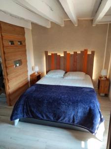 a bedroom with a large bed with a wooden headboard at La Brousse Kacha in Malleret-Boussac