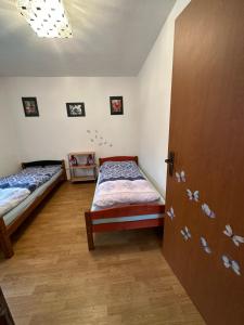 ノヴェー・フラディにあるDomeček u Terčina Údolíのベッドルーム1室(ベッド2台、ドア付)