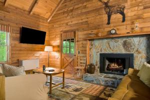 a living room with a fireplace in a log cabin at A Little Leeway in Ellijay