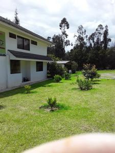 una casa con un patio con césped verde en Hostería la Gaviota en Riobamba