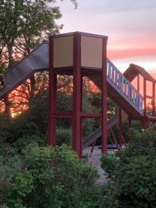 a slide in a park with a sunset in the background at Løgballe Camping & Cottages in Stouby