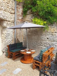 a table with an umbrella and two chairs at La Grotte du Bonheur in Cangey