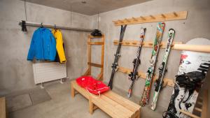 una habitación con esquís colgando de la pared y un banco en Full Circle Apartments, en Niseko