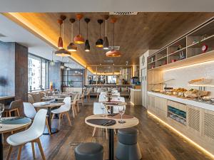 un ristorante con tavoli, sedie e bancone di Ibis Styles Lisboa Centro Liberdade NE a Lisbona