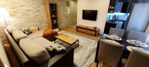 uma sala de estar com um sofá e uma televisão em Centrum Bridge Apartment em Pärnu