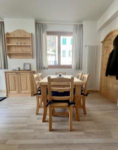 jadalnia z drewnianym stołem i krzesłami w obiekcie Pizzo Stella - appartamento con box w mieście Campodolcino