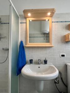 W łazience znajduje się biała umywalka i lustro. w obiekcie Pizzo Stella - appartamento con box w mieście Campodolcino