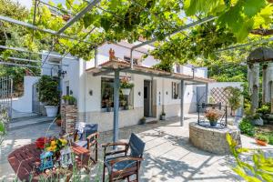 une terrasse avec une table et des chaises devant une maison dans l'établissement Karderina Cozy Cottage by the River, à Skopelos