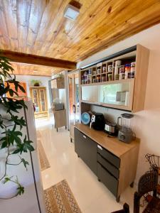 Il comprend une cuisine avec un comptoir et un plafond en bois. dans l'établissement Casa Jataí, à Alto Paraíso de Goiás