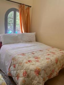 a bedroom with a bed with a floral comforter and a window at Hôtel Restaurant ASGAOUR in Amlouggui +31 photos