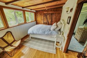 a bedroom in a log cabin with a bed and a chair at Rivers Breeze A Wine Country Escape in Healdsburg