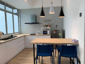 a kitchen with a wooden table and blue chairs at Entire house in town centre #WIFI#NETFLIX in Kuala Terengganu