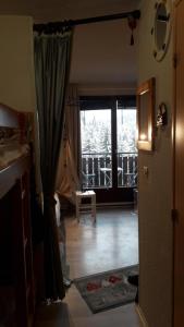 una sala de estar con una puerta que da a un balcón en Les Montagnes, en Bellevaux