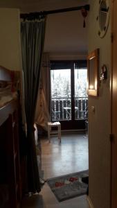 una sala de estar con una puerta que da a un balcón en Les Montagnes, en Bellevaux