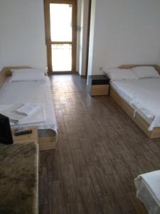 een kamer met 2 bedden, een tafel en een raam bij Guest House Lili in Petrich