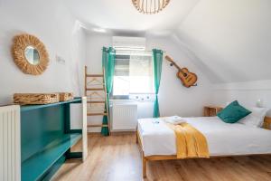 ein Schlafzimmer mit einem Bett und einer Gitarre an der Wand in der Unterkunft KAWAŁEK ŚWIATA in Darłowo