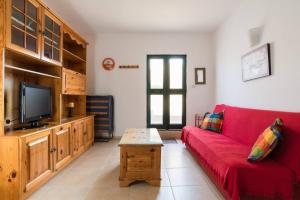 a living room with a red couch and a tv at Spacious, modern apartment near beach andclose to st. Julians in Naxxar
