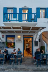 un grupo de personas sentadas en mesas frente a un edificio en Liana sunset, en Mykonos ciudad