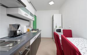 a kitchen with a counter and red chairs in a room at 1 Bedroom Lovely Apartment In Pula in Pula +11 photos