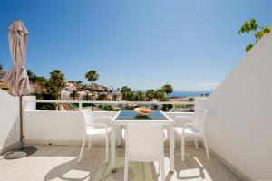 balcón con mesa, sillas y vistas al océano en Studio with sea view in San Eugenio, en Adeje