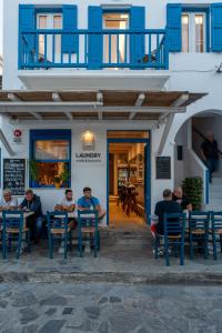 un grupo de personas sentadas en mesas frente a un edificio en Liana sunset, en Mykonos ciudad