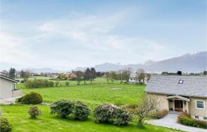 una casa en un campo con montañas en el fondo en Stunning Home In Kjerstad With Wifi, en Kjerstad