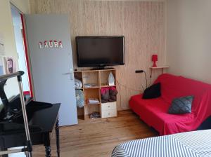 salon z czerwoną kanapą i telewizorem z płaskim ekranem w obiekcie studio type 1bis w mieście Gourdon