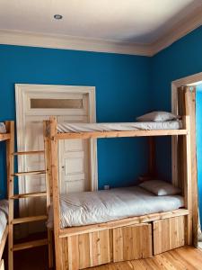 two bunk beds in a room with a blue wall at The Pink House in Faja Grande