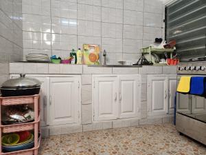 cocina con armarios blancos y encimera en KADIDJA APARTMENTS & SUITES Hedzranawoe, en Lomé