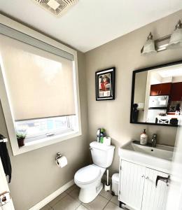 een badkamer met een toilet, een wastafel en een raam bij Home in Downtown in Toronto
