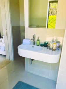 y baño con lavabo y espejo. en Vilamoura Pine Hills Luxury Apartment, en Quarteira