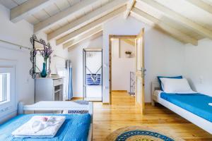 Habitación con 2 camas y pasillo con puerta en Karderina Cozy Cottage by the River, en Skopelos Town