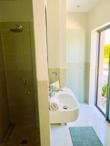 ein Bad mit einem Waschbecken und einer Dusche in der Unterkunft Vilamoura Pine Hills Luxury Apartment in Quarteira