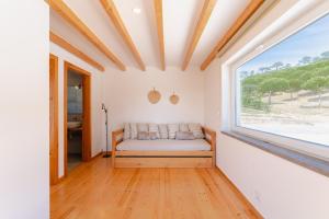 a room with a bed and a large window at Monte da Várzea da Rainha in Óbidos