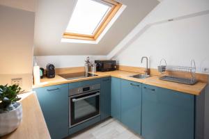 a kitchen with blue cabinets and a window at Modern apartement in the city center. in Poissy