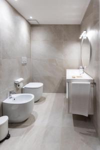 a bathroom with a white toilet and a sink at La casa del Vescovo in Imola