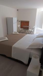 a large white bed in a room with two chairs at Di Fronzo Guest House T in Triggiano