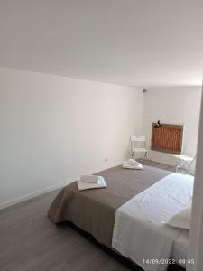 a white bedroom with a bed and a window at Di Fronzo Guest House T in Triggiano