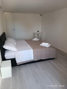 - une chambre avec un grand lit et 2 tables blanches dans l'établissement Di Fronzo Guest House T, à Triggiano