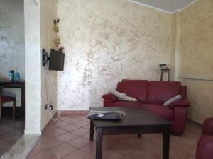 ein Wohnzimmer mit einem roten Sofa und einem Tisch in der Unterkunft Dimora Guaceto in Brindisi