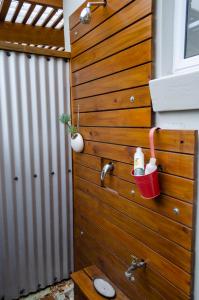 a bathroom with a wooden wall with a bucket at The Khaya Accommodation for the Soul in Lorraine