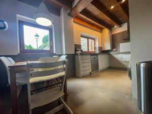 a kitchen with a table and chairs and a window at Cal Peró Casa de montaña in Caixáns