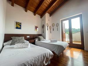 CaixánsにあるCal Peró Casa de montañaのベッドルーム1室(ベッド2台、大きな窓付)