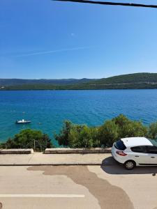 a white car parked next to a large body of water at Ana in Neum