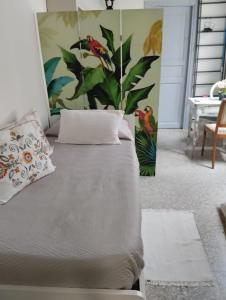Bett in einem Zimmer mit einer Pflanze an der Wand in der Unterkunft Lacasadilu in Neapel